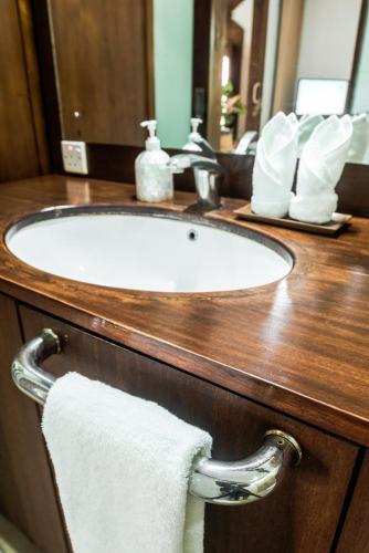 a bathroom sink with a white towel on a counter at Segara Beach House Villa - Kuta in Kuta