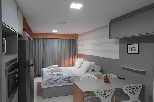 a small bedroom with a bed and a kitchen at Flat Super Confortável em Porto de Galinhas in Porto De Galinhas