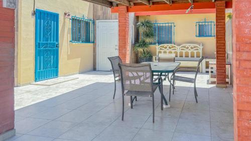 een patio met een tafel en stoelen en blauwe deuren bij Vista de Oro in Puerto Peñasco