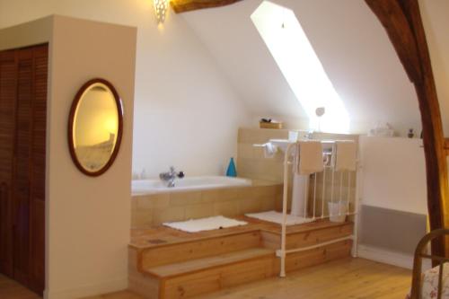 uma casa de banho com uma banheira, um lavatório e um espelho. em Le Clos de Ligré em Ligré