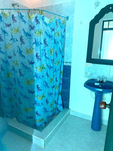 a bathroom with a blue shower curtain with fish on it at Chicala relax C4 in Girardot