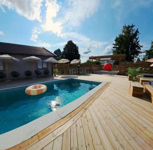 a large swimming pool with a wooden deck at Hotell Gästis Tierp in Tierp