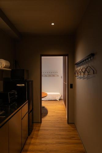 a room with a kitchen with a door to a bedroom at Flower Base HIMAWARI in Fukuoka