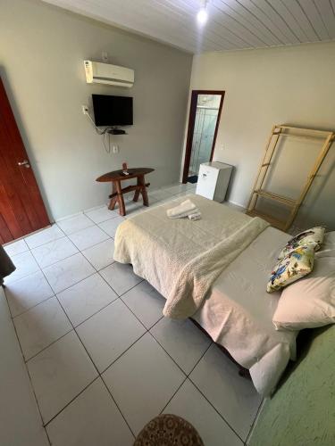 a bedroom with a bed and a tv on the wall at Pousada e restaurante Jardim do Cerrado MT in Nobres