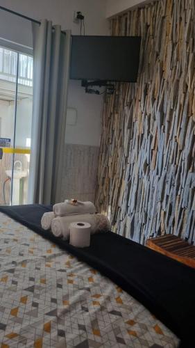 a room with two beds with towels and a wall at Pousada Love Piri in Pirenópolis