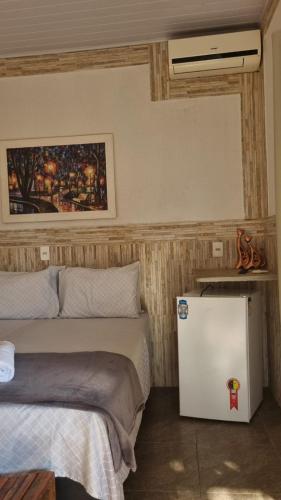 a room with two beds and a small refrigerator at Pousada Love Piri in Pirenópolis