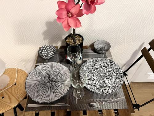 a table with a vase of flowers and glasses on it at Studio Arcueil, maisons des examens, ligne 14, proche Paris in Arcueil