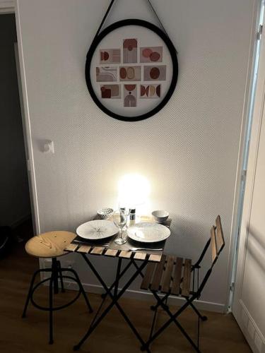 a table with two chairs and a light on it at Studio Arcueil, maisons des examens, ligne 14, proche Paris in Arcueil