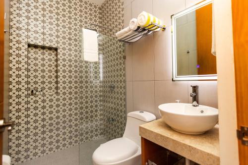 a bathroom with a toilet and a sink and a mirror at Casa Itzae Hotel Boutique in Mérida