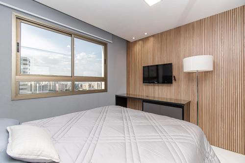 a bedroom with a bed and a flat screen tv at Apart-hotel Brasil 21 in Brasilia