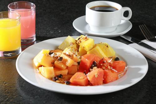 a plate of food with fruit and a cup of coffee at Holiday Inn Express - Monterrey - Fundidora by IHG in Monterrey