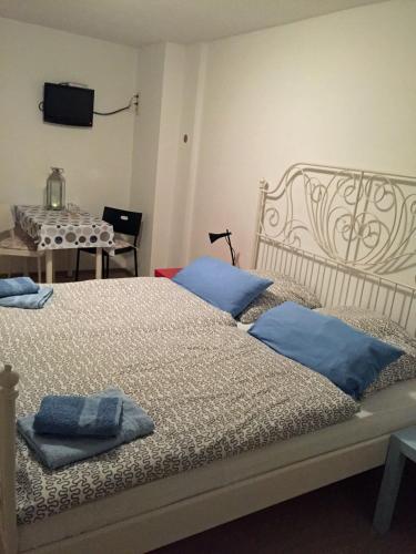 a bedroom with two beds with blue pillows on them at Pension da Luigi in Greifswald