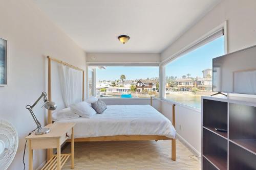 a bedroom with a bed and a large window at Newport Bay Front Vacation Home in Newport Beach