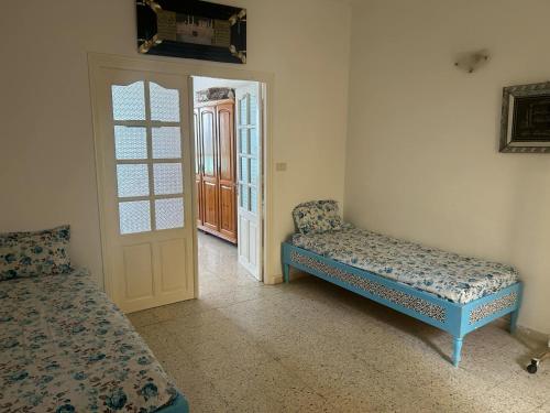 a room with a bed and a door with a window at Pied dans l'Eau à Sousse méditerranéen in Sousse