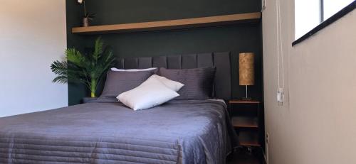 a bedroom with a bed with purple sheets and pillows at Apartamento Confortável Inteligente in Poços de Caldas