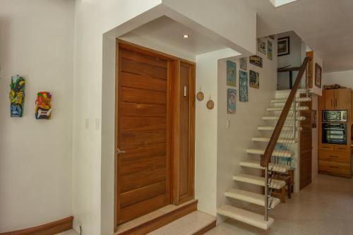 a hallway with a wooden door and stairs at Casa Ambar in Puerto Viejo