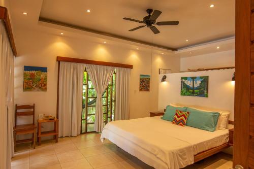 a bedroom with a bed and a ceiling fan at Casa Ambar in Puerto Viejo