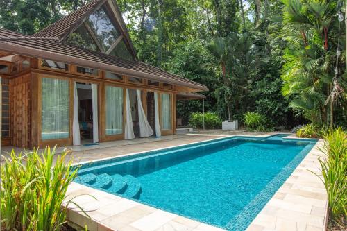 a swimming pool in front of a house at Casa Ambar in Puerto Viejo