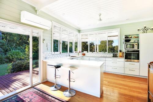 a kitchen with white countertops and glass windows at Kiah - By Berry Getaways in Berry