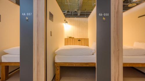 a room with two beds and a mirror at EIGHT POINT INN Kanazawa in Kanazawa