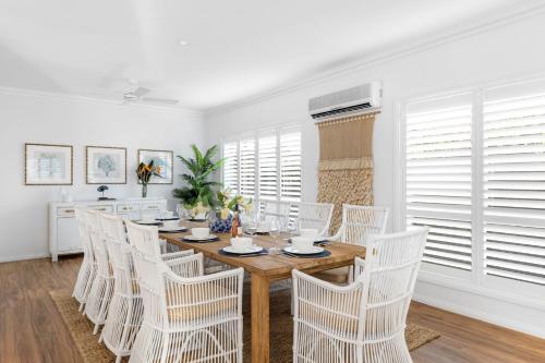 a dining room with a wooden table and white chairs at Berry Vista - By Berry Getaways in Berry