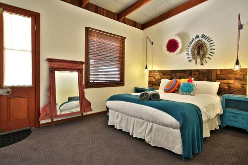 a bedroom with a large bed and a mirror at Amaroo House - By Berry Getaways in Berry