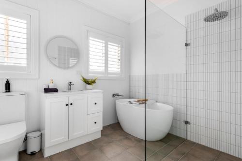 a white bathroom with a tub and a sink at Berry Vista - By Berry Getaways in Berry