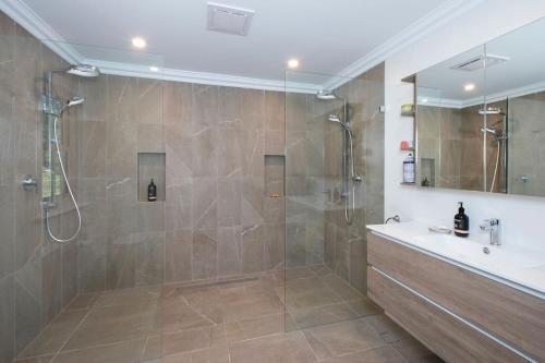 a bathroom with a shower and a sink at Possum Gully Lodge -By Berry Getaways in Berry