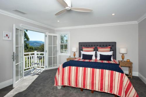a bedroom with a bed and a balcony at Possum Gully Lodge -By Berry Getaways in Berry