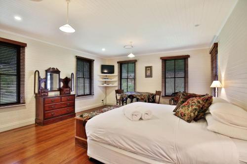 a bedroom with a bed with two towels on it at The Cottage - By Berry Getaways in Berry