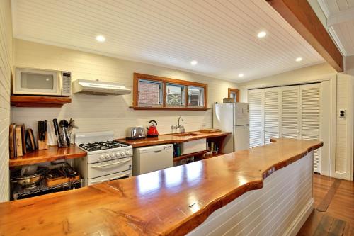 a kitchen with a counter and a stove top oven at The Cottage - By Berry Getaways in Berry