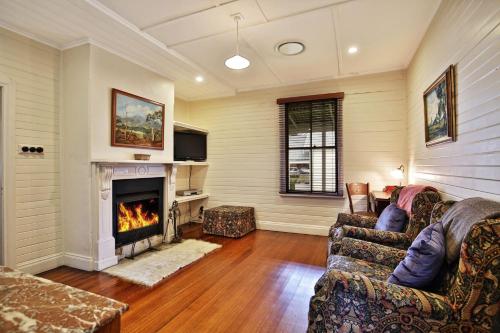 a living room with a couch and a fireplace at The Cottage - By Berry Getaways in Berry