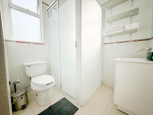 a white bathroom with a toilet and a shower at Acogedor y hermoso cerca del Foro Sol, AICM y Coyoacán in Mexico City