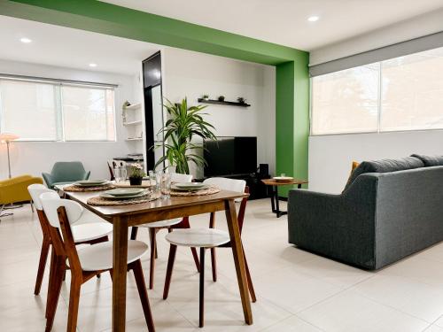 a dining room with a table and a couch at Acogedor y hermoso cerca del Foro Sol, AICM y Coyoacán in Mexico City