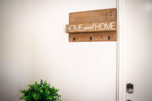 a sign that reads home sweet home next to a door at Charming 3BR Apartment in the Heart of Richmond in Richmond