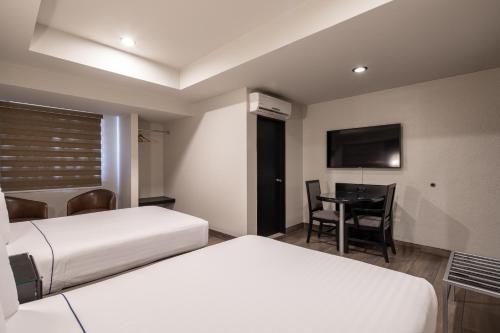 Ein Bett oder Betten in einem Zimmer der Unterkunft Hotel Astor Tijuana