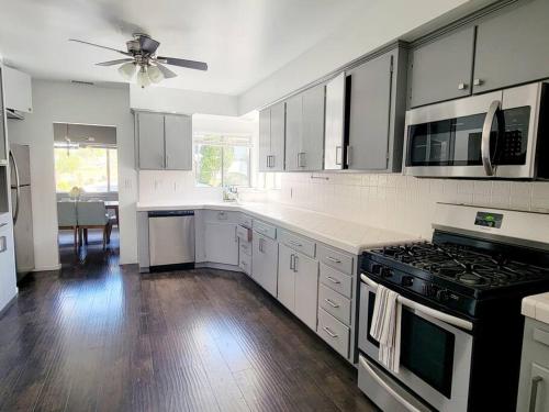 a kitchen with white appliances and a ceiling fan at Spacious & Immaculate Haven near Downtown SD in San Diego