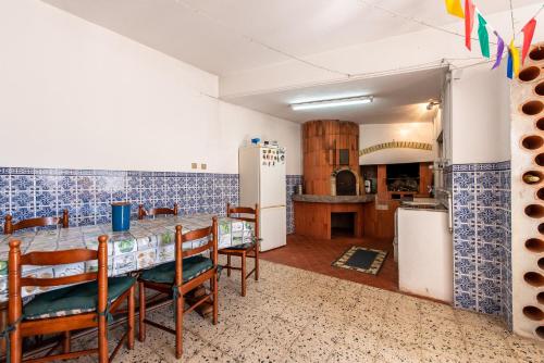 a kitchen with a table and chairs and a refrigerator at Cantinho alegre em Cascais in Cascais