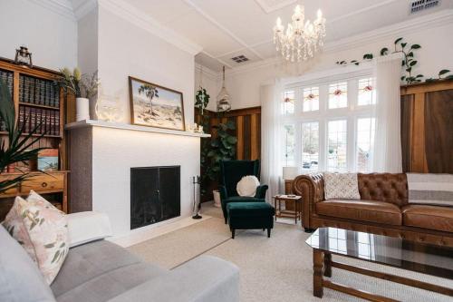 a living room with a couch and a fireplace at Harmony House - CBD in Launceston
