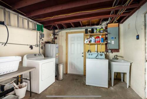 a laundry room with two washers and a sink at Coral Cottage Pool & Beach & Golf in Cocoa Beach