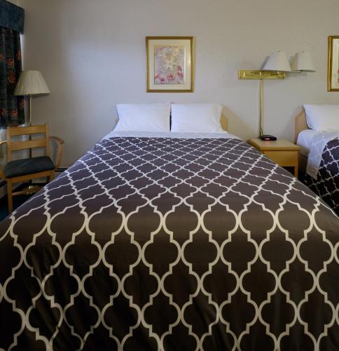 a bedroom with a bed with a black and white comforter at Perfect Inns & Suites in Weyburn