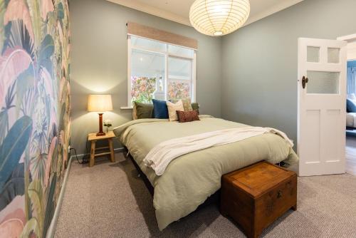 a bedroom with a large bed and a window at Mabel's Cottage - By Berry Getaways in Berry