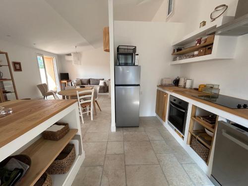 une cuisine avec un réfrigérateur en acier inoxydable et une table dans l'établissement Maison rénovée T3 avec balcon et climatisation au cœur de Collioure - FR-1-309-457, à Collioure