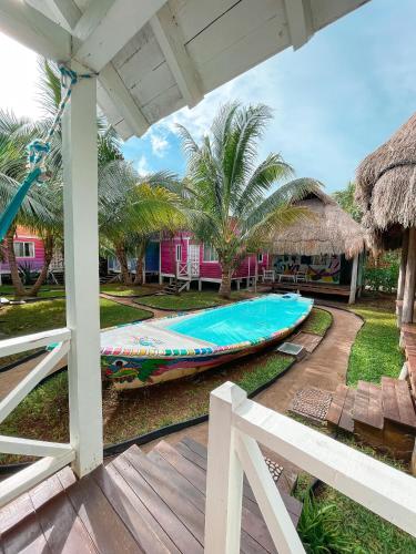 a swimming pool with a boat next to a house at Whyknot Holbox in Holbox Island