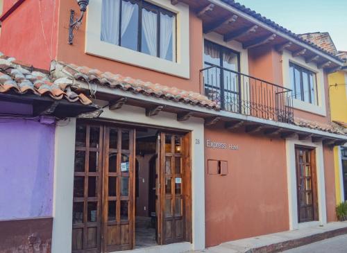a building with wooden doors and a balcony at Axkan Express in San Cristóbal de Las Casas