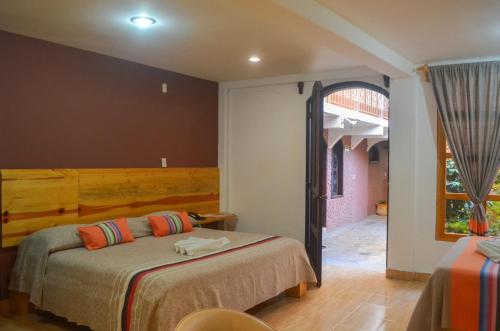 a bedroom with two beds and an open doorway at Axkan Express in San Cristóbal de Las Casas