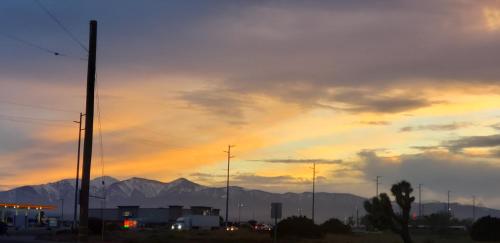 a sunset with a rainbow in the sky over mountains at Studio 6 Suites Hesperia, CA West Main Street I 15 in Hesperia