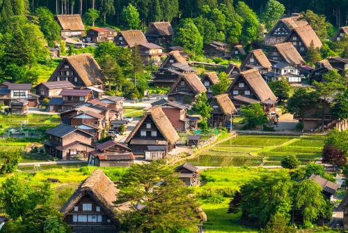 a village of houses on a hill with trees at Tabist Ryokufuen Kiyoharu in Takayama