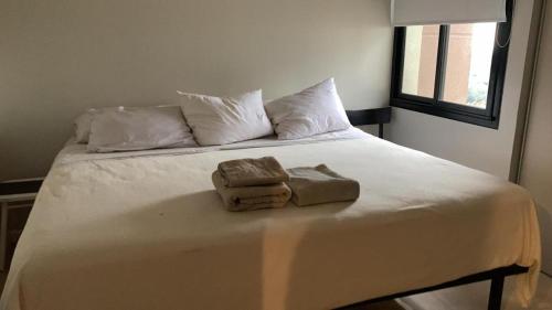a bed with two towels on top of it at Apart buena vista in Yerba Buena