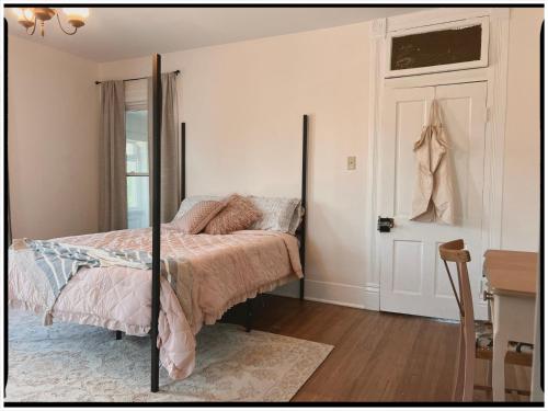 a bedroom with a bed and a desk and a door at Thames Home in Taylor